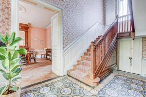 een sierlijke trap in een huis met roze muren bij Maison familiale - 11 personnes - Labège in Labège