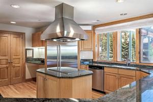 a kitchen with a stainless steel hood over a kitchen island at Beaver Creek Lodge 411 in Beaver Creek