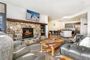 uma sala de estar com uma grande lareira de pedra em Highlands Lodge 302 em Beaver Creek