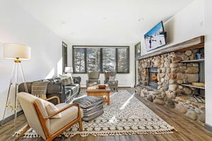 uma sala de estar com lareira de pedra em Highlands Lodge 302 em Beaver Creek