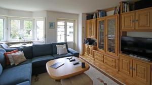 - un salon avec un canapé bleu et une table dans l'établissement Ferienwohnung am Rotbach, à Sonthofen