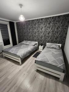 a bedroom with two beds and a wall at apartament u Irenki in Harklowa