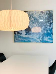 霍森斯的住宿－Scandinavian House Hotel-Lunden- Central 3 bedroom house，挂在桌子上的一盏灯,墙上挂着一幅画