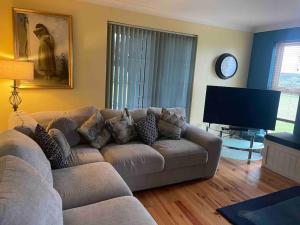 sala de estar con sofá y TV de pantalla plana en Easkey House en Sligo