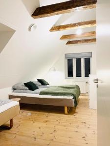 Schlafzimmer mit einem Bett mit grüner Bettwäsche und Kissen in der Unterkunft Scandinavian House Hotel-Lunden- Central 3 bedroom house in Horsens