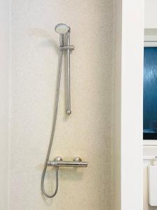un soffione doccia su una parete in bagno di Scandinavian House Hotel-Lunden- Central 3 bedroom house a Horsens