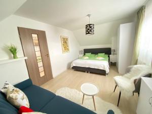 a living room with a blue couch and a bed at Cazare La Luiza in Şura Mare