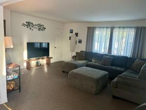 a living room with a blue couch and a flat screen tv at A Spacious & Blissful Stay in queens in Laurelton