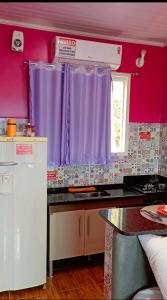 eine Küche mit lila Vorhängen und einer Arbeitsplatte in der Unterkunft Pousada Linda Vista in Domingos Martins