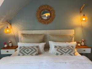 1 dormitorio con cama blanca con almohadas y espejo en Estelle, en Stromberg