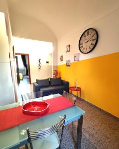 sala de estar con mesa y reloj en la pared en Appartamento Al Novecento Novi, en Novi Ligure