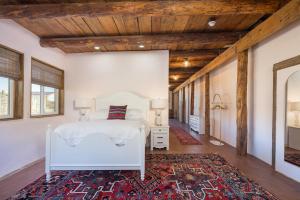 a bedroom with a white bed and a rug at Willow Street Cottages in Bluff