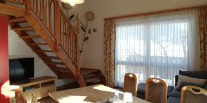 ein Wohnzimmer mit einer Treppe, einem Tisch und Stühlen in der Unterkunft Abenteuerhof in Weißenbach