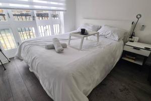 a white bed with a table on top of it at Stylish room kingsize bed 1 stop from Wembley stadium in Wealdstone