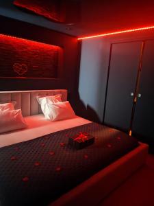 ein Schlafzimmer mit einem Bett mit einem Geschenk in der Unterkunft Love room - L'étincelle secrète in Le Ségur-Suech