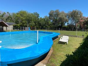 una piscina azul con una silla en un patio en Casa Quinta Buen Descanso en San Pedro