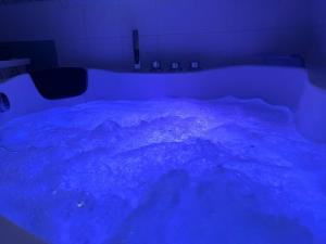 a bed in a room with a blue light at Suite Jacuzzi-Cinéma in Les Clayes-sous-Bois