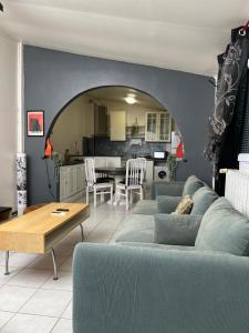 a living room with a blue couch and a table at Suite Jacuzzi-Cinéma in Les Clayes-sous-Bois