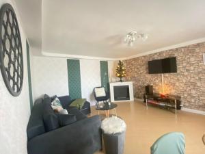 un soggiorno con divano blu e TV di Villa Luiza a Şura Mare