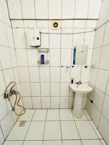 un bagno piastrellato bianco con lavandino e specchio di Apart 71 a Istanbul