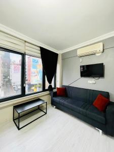 ein Wohnzimmer mit einem schwarzen Sofa und einem TV in der Unterkunft Apart 71 in Istanbul