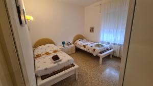una piccola camera da letto con due letti e una finestra di A due passi dal mare a Santa Marinella