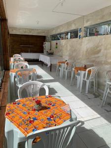 un restaurante con mesas blancas, sillas y mesas blancas y un registrador en Pousada Casa Porto, en Porto de Galinhas