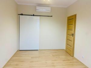 Habitación vacía con puerta y suelo de madera en Gold Apartament, en Świdnik