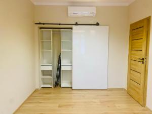a room with a white closet with a door at Gold Apartament in Świdnik