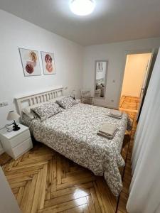 een slaapkamer met een bed en een houten vloer bij Apartamento acogedor in Santander