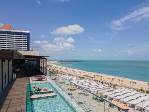 um hotel com uma piscina ao lado de uma praia em Praiano Hotel em Fortaleza