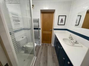 a bathroom with a glass shower and a sink at Kew Gardens Village in Kew