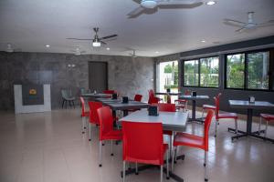 Hotel y Villas Costa del Sol في ميريدا: غرفة طعام مع طاولات وكراسي حمراء