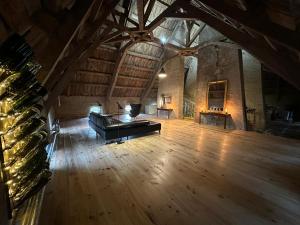 ZONE BLEUE في Hyds: غرفة كبيرة فيها بيانو في عمارة ذات أرضيات خشبية