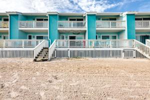 a building on the beach next to the sand at Bayfront Texas Escape with Balcony and Pool Access! in Rockport