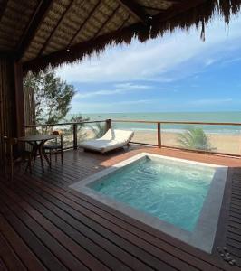 a hot tub on a deck with a view of the beach at Collina Beach in Amontada