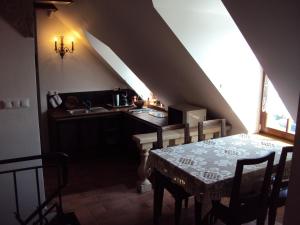 a dining room with a table and a kitchen at Castle Kaštieľ Kotešová in Kotešová