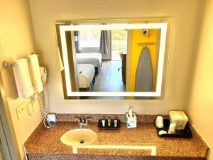 baño con lavabo y espejo grande en Days Inn by Wyndham St George en Saint George