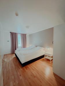 フーサヴィークにあるガムリ　スコリン　フーサヴィークの白い大きなベッドルーム(ベッド1台、テーブル付)