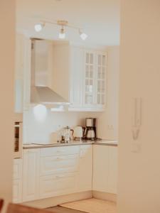 a white kitchen with white cabinets and appliances at Gamli Skólinn Húsavík in Húsavík