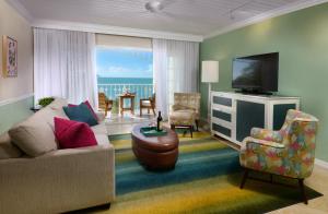 a living room with a couch and a television at Ocean Key Resort & Spa, a Noble House Resort in Key West