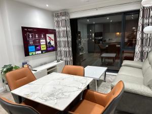 ein Wohnzimmer mit Tisch und Couch in der Unterkunft Aqua Dream Luxury Apartment-Coyles Place at Portland 88 in Belfast