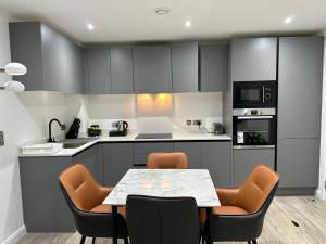 eine Küche mit einem Tisch und Stühlen darin in der Unterkunft Aqua Dream Luxury Apartment-Coyles Place at Portland 88 in Belfast