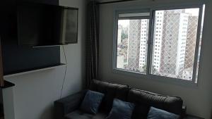 uma sala de estar com um sofá e uma janela em Metrô Brás Centro Av Paulista Bem Localizado em São Paulo