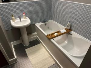 a bathroom with a sink and a tub and a toilet at Luxury Two Bedroom En-Suité Apartment in Manchester