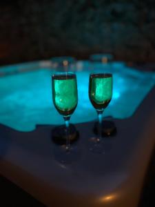 zwei Weingläser neben einem Pool in der Unterkunft Love room - L'étincelle secrète in Le Ségur-Suech