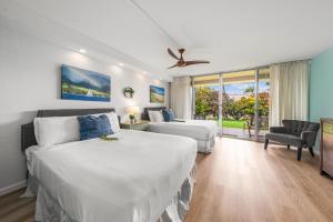 a hotel room with two beds and a window at Eldorado L102 · EL L102 Renovated 1BD Condo w Pool AC Beach Caba in Kahana +42 photos