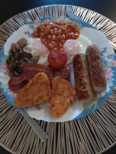 a plate of breakfast food with sausage beans and eggs at QT in Gildingwells