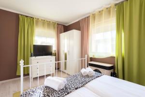 um quarto com uma cama, uma televisão e cortinas verdes em Barbarosa Sweet Dream 3 em Budapeste