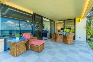 a patio with wicker chairs and a table and windows at Polo Beach Club 106 condo in Wailea